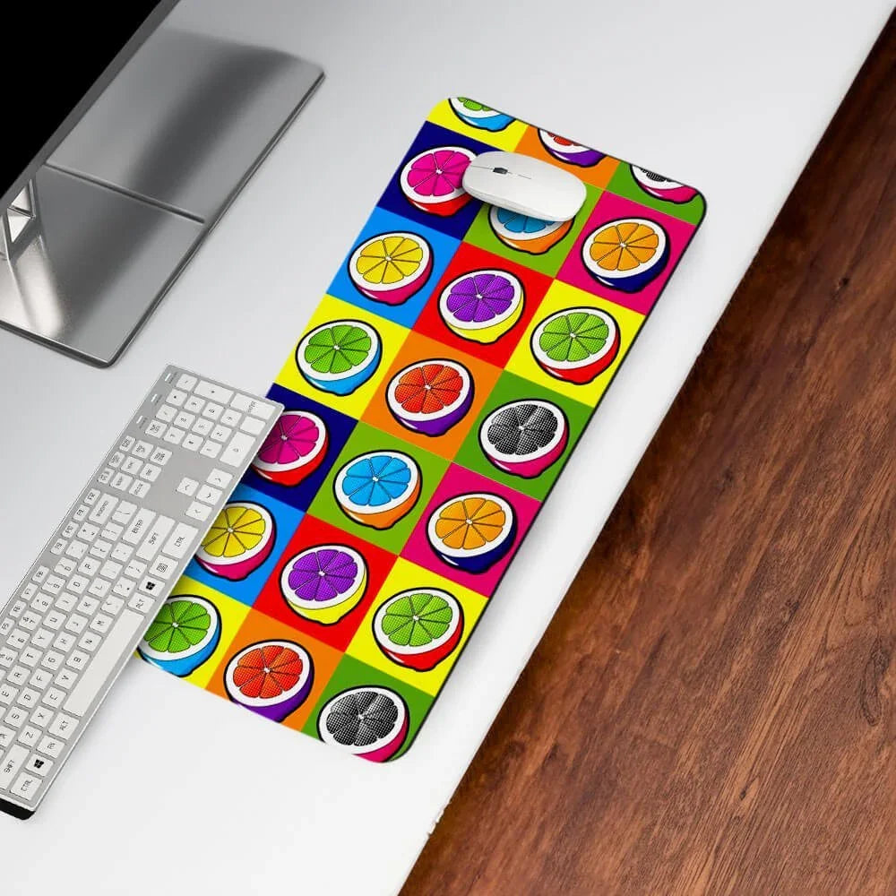 Colorful desk mat with citrus fruit pop art design on a modern office desk with keyboard and mouse.