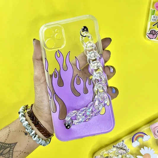 Clear phone case with purple flame design and chunky chain charm, held in hand on yellow background