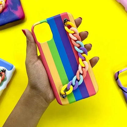 Hand holding a rainbow striped phone case with colorful chain on yellow background
