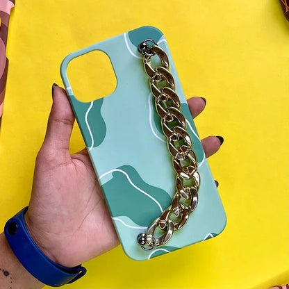 Green patterned phone case with gold chain grip, held in hand, on yellow background