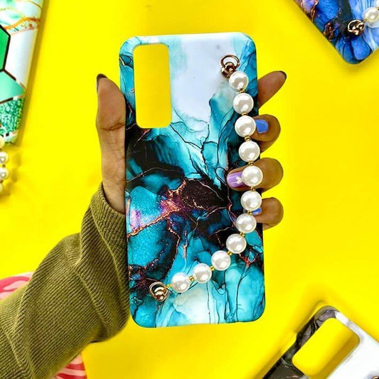 Blue marble design phone case with chain of pearls, held in hand on yellow background