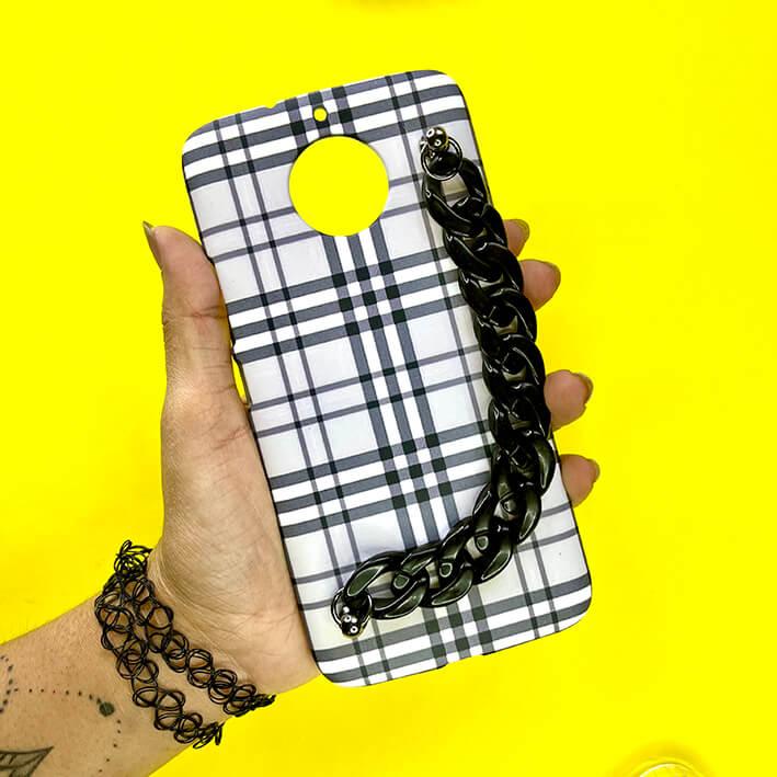 Plaid phone case with black chain handle held in hand on yellow background