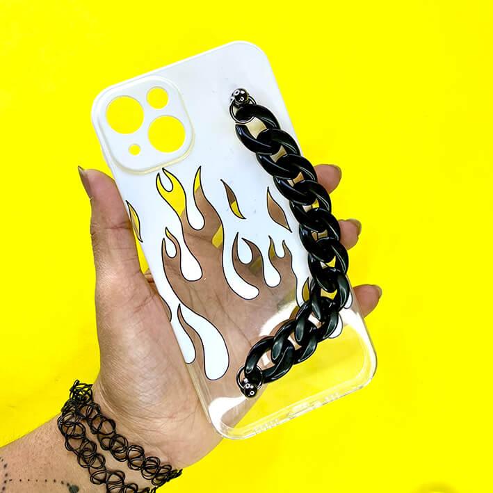 Transparent flame phone case with black chain handle, held against yellow background
