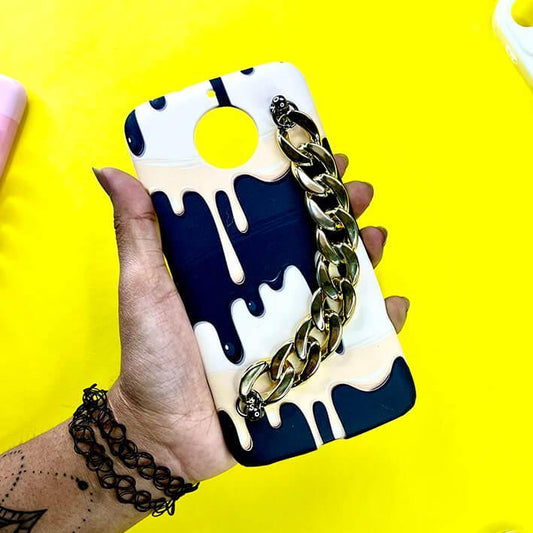 Hand holding a navy and cream drip design phone case with a gold chain handle on yellow background.