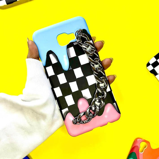 Checkered phone case with blue and pink drip design and silver chain, held on yellow background