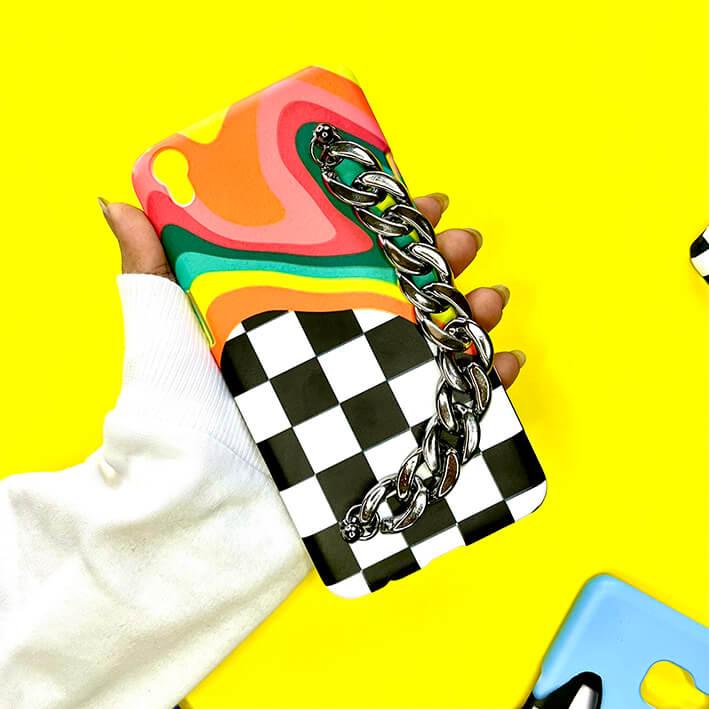 Colorful phone case with black and white checkerboard pattern and chunky silver chain handle