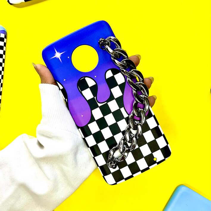 Checkered phone case with purple drip design and silver chain, trendy mobile cover on yellow background