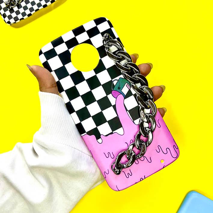 Checkered phone case with pink drip design and chunky silver chain charm, held in hand