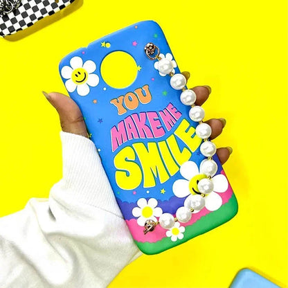 Colorful phone case with 'You Make Me Smile' text, daisies, smiley faces, and pearl chain charm