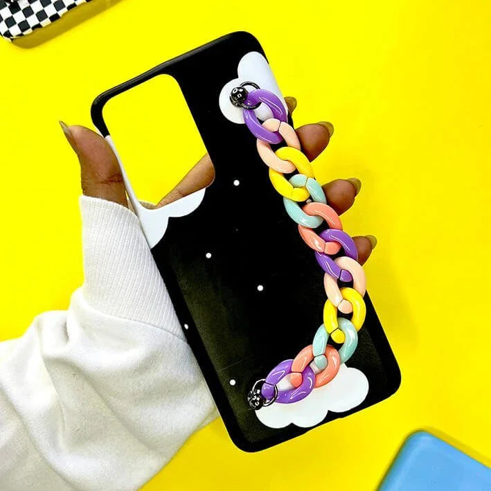 Black phone case with white clouds and a pastel rainbow chain, held in hand, on yellow background.