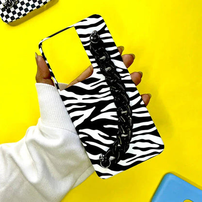 Zebra print phone case with black chain handle held in hand on yellow background