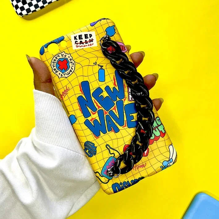 Yellow New Wave chain phone case with cartoon graphics held in hand on yellow background