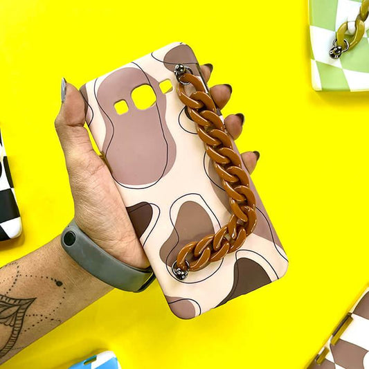 Brown abstract chain phone case with wavy pattern, held in hand on yellow background