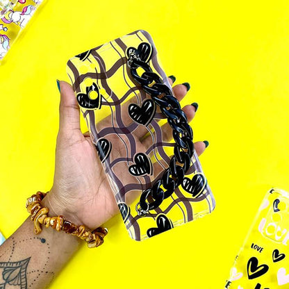Clear phone case with black hearts, wavy lines, and chunky black chain, held in hand