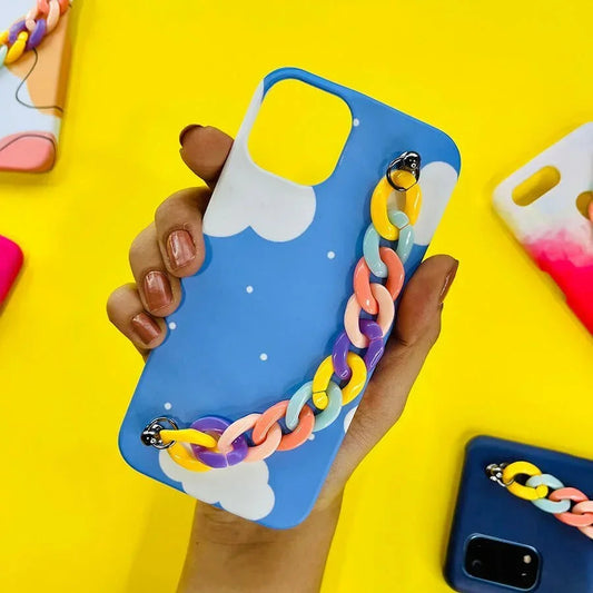 Blue cloud phone case with pastel chain charm, held in hand, on yellow background