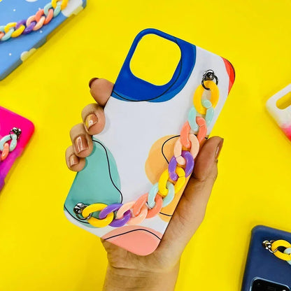 Colorful chain charm phone case with abstract design held in hand on yellow background