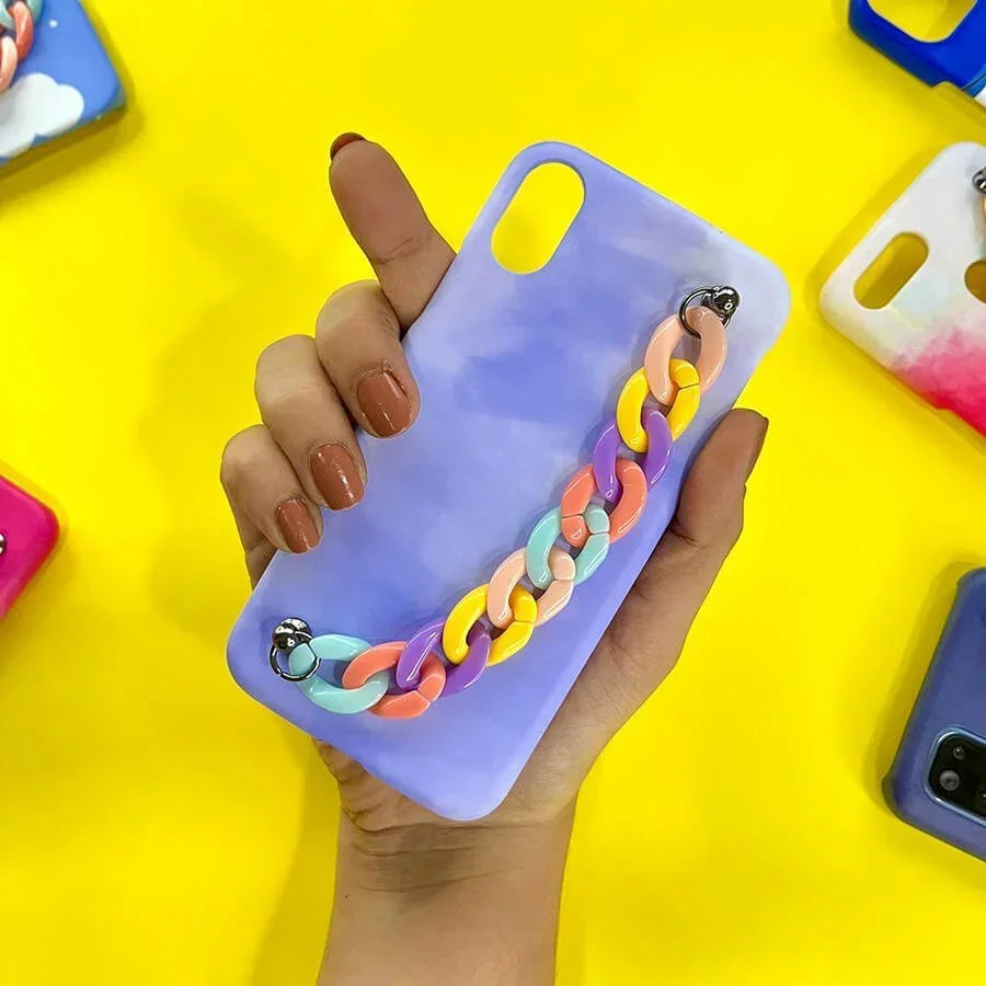 Purple phone case with multicolor chain charm held in hand on yellow background