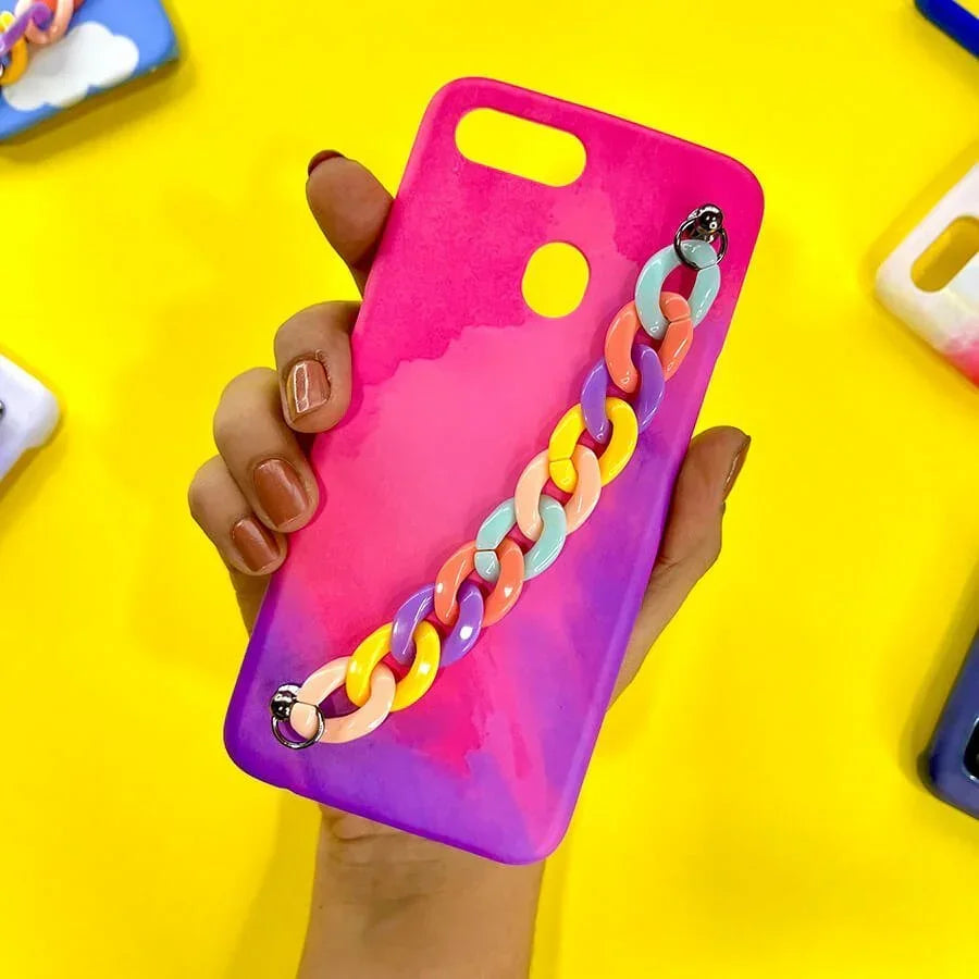 Pink and purple gradient phone case with colorful chain charm held in hand on yellow background