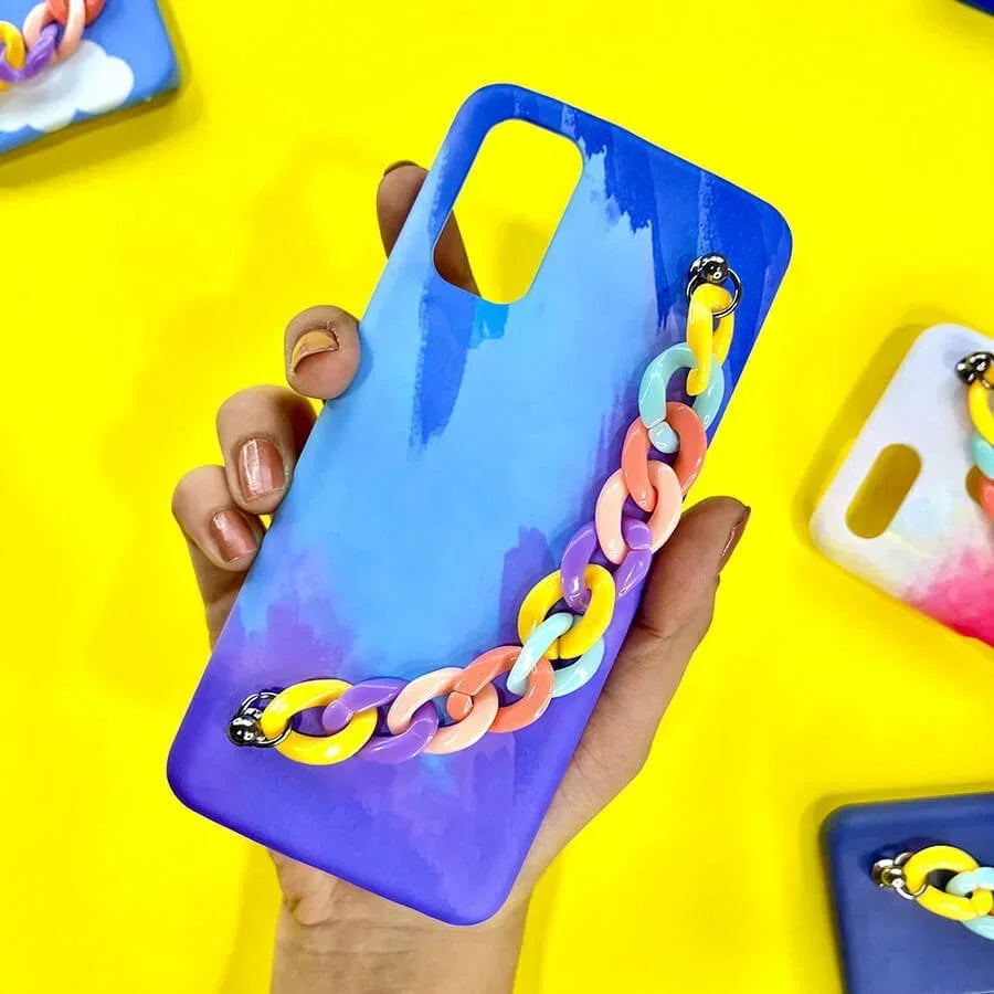 Blue pastel phone case with colorful chain charm, held in hand, on yellow background