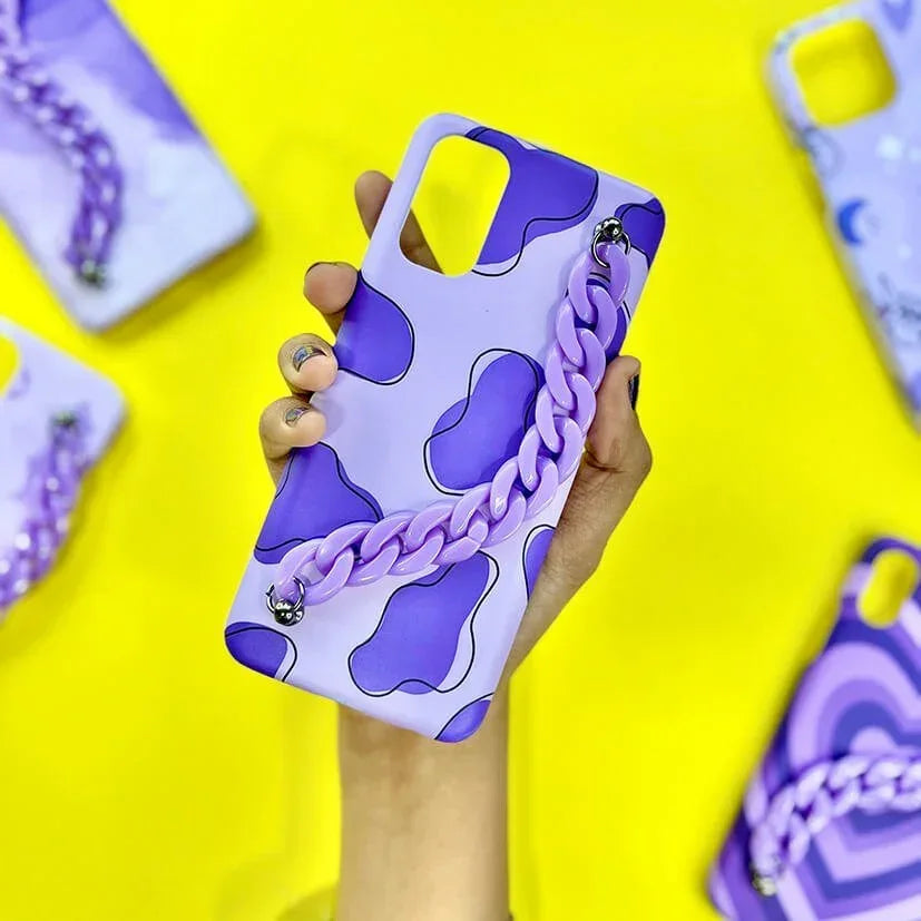 Purple abstract pattern phone case with matching chunky chain, held in hand on yellow background.