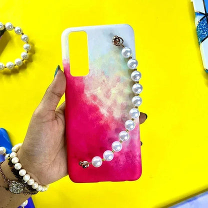 Pink gradient phone case with pearl chain charm, held by hand, on yellow background