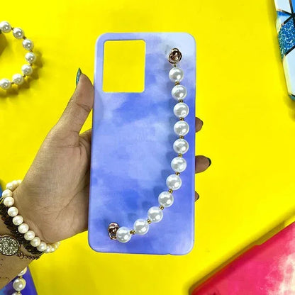 Hand holding blue gradient phone case with pearl chain charm, stylish accessory background.