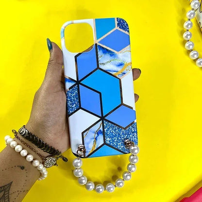 Blue geometric marble phone case with pearl chain handle held in hand on yellow background