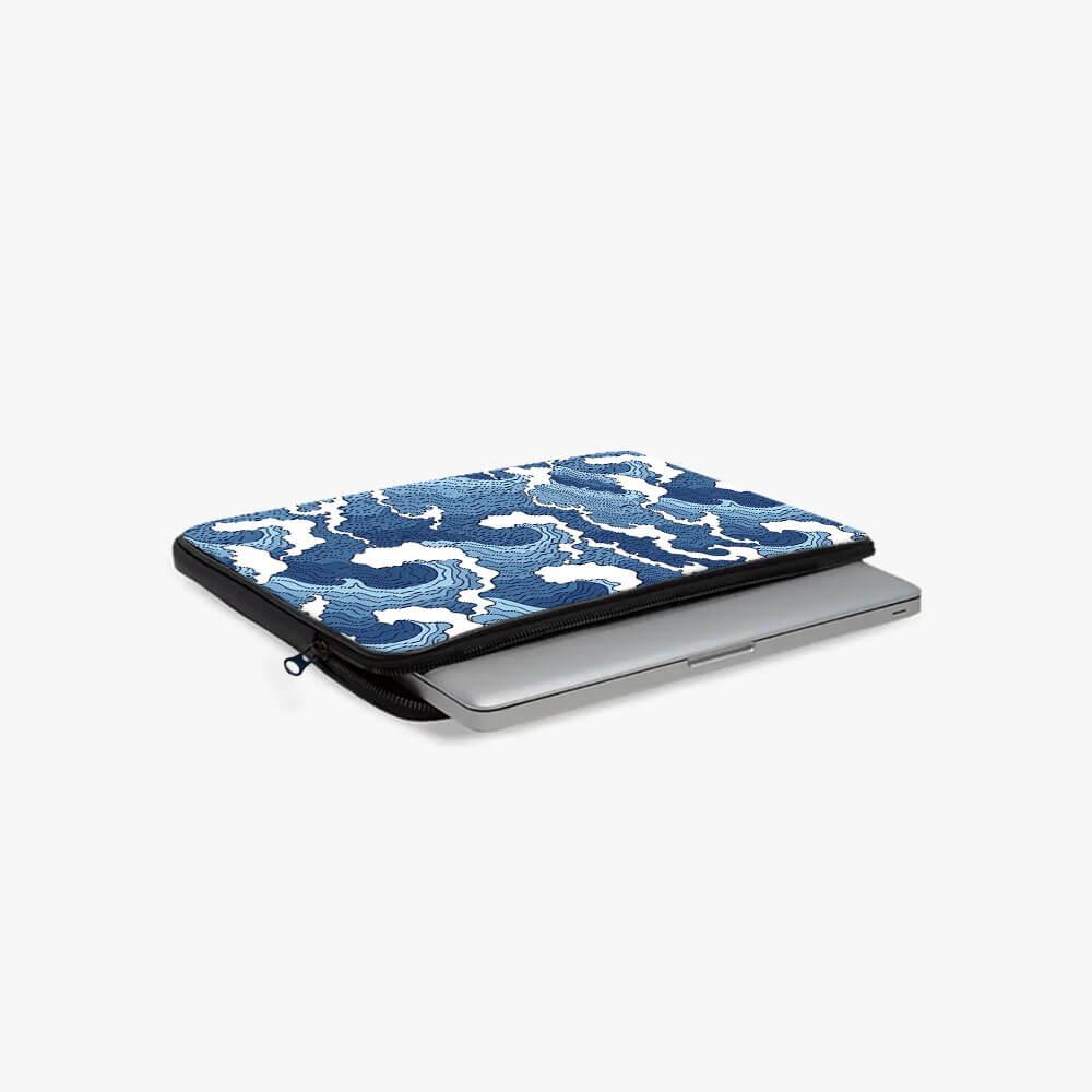 Blue and white patterned laptop sleeve with zipper, partially holding a silver laptop