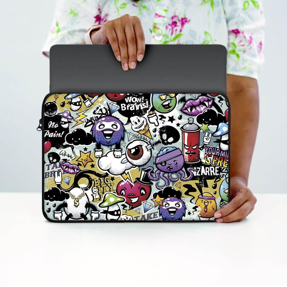 Person holding a 13-inch laptop sleeve with colorful cartoon and graffiti designs.