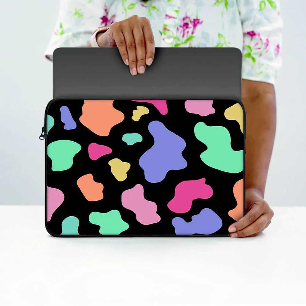Person holding colorful abstract pattern laptop sleeve with zipper on white table