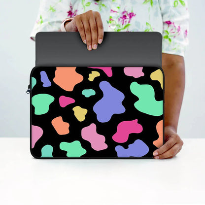 Person holding colorful abstract pattern laptop sleeve with zipper on white table