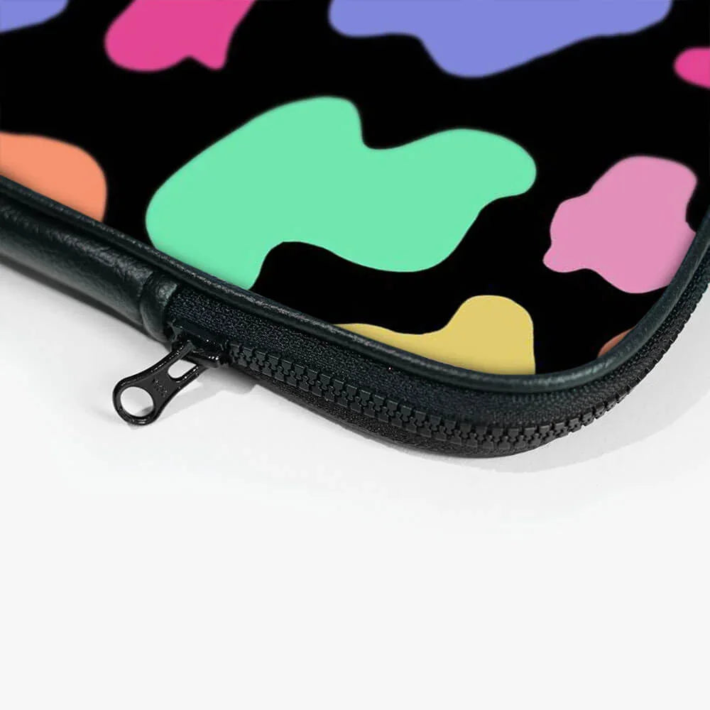 Close-up of black laptop sleeve with colorful abstract pattern and zip closure