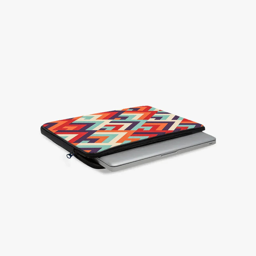Colorful zigzag patterned laptop sleeve partially open with a silver laptop inside