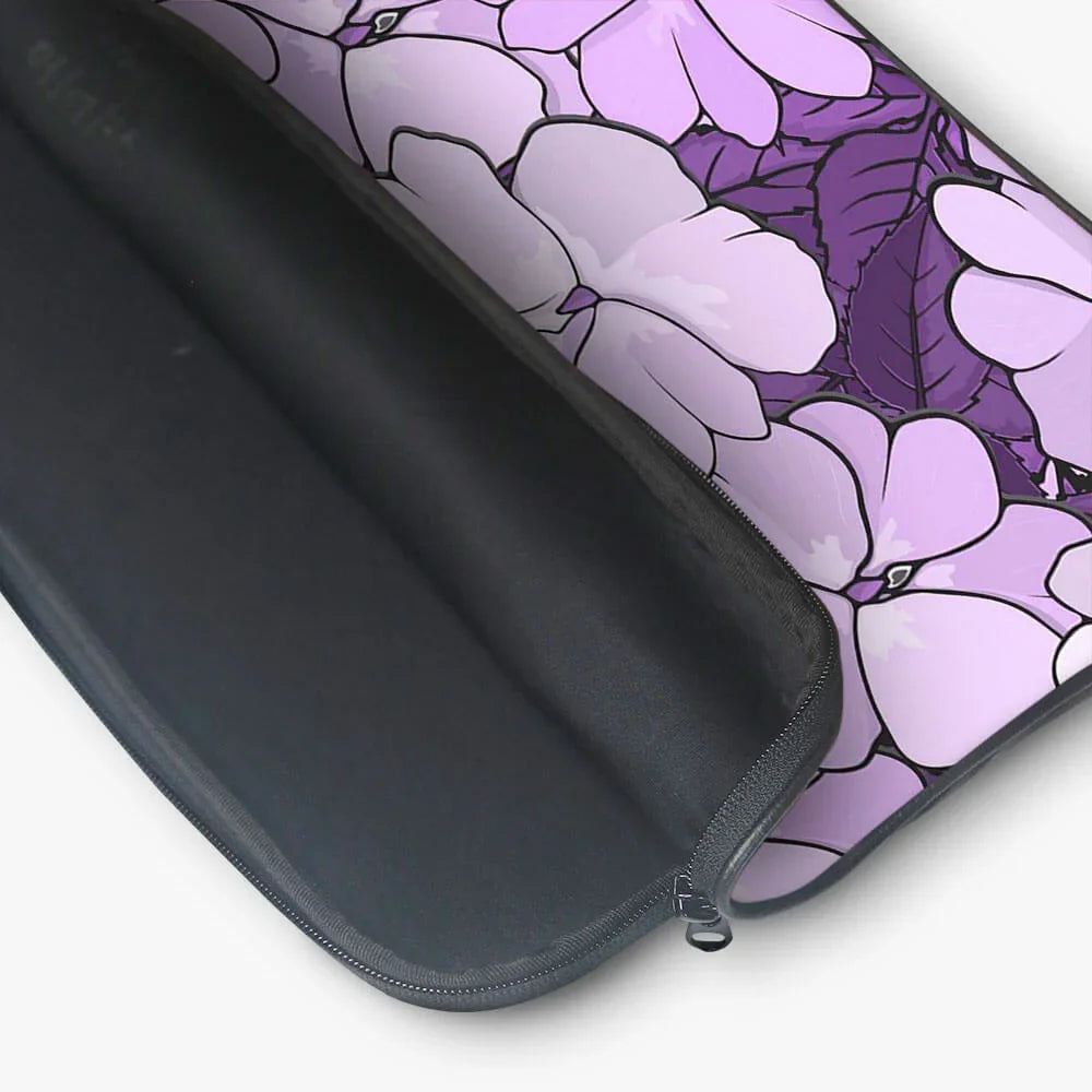 Purple floral laptop sleeve with black zipper, open to show interior padding.