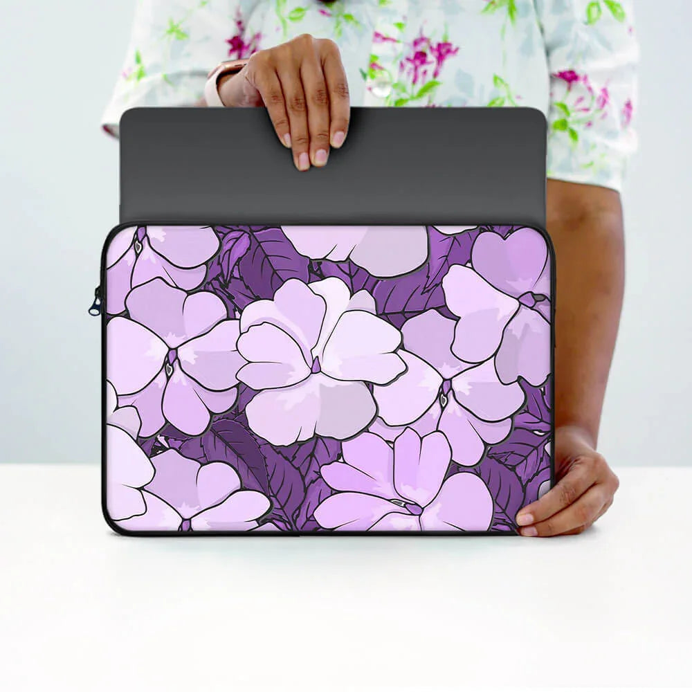 Purple floral laptop sleeve with zipper, held by person, stylish protective case