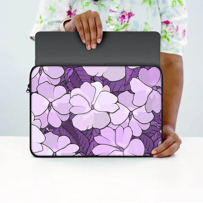 Purple floral laptop sleeve with zipper, held by person, stylish protective case