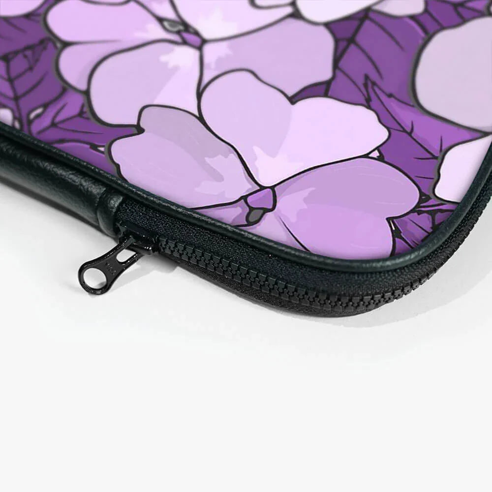 Close-up of laptop sleeve with purple floral design, black zipper detail, 13-inch size