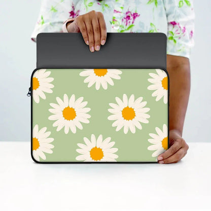 Person holding a green laptop sleeve with white daisy flower print, 13-inch size