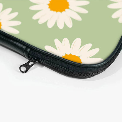 Closeup of a floral laptop sleeve zipper, green background with white daisy print