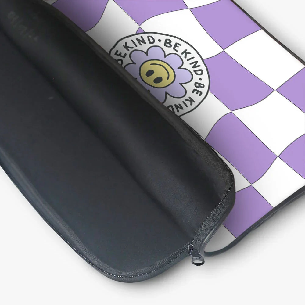Black laptop sleeve with purple and white checkered design and 'Be Kind' flower graphic