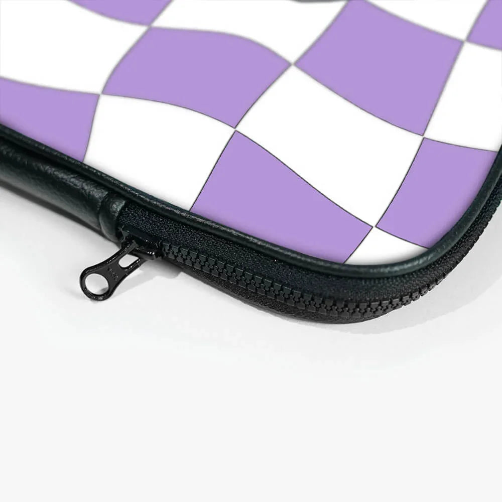 Close-up of laptop sleeve with purple and white checkered pattern and black zipper