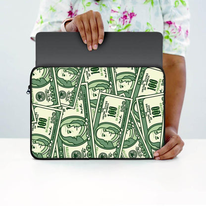 Person holding laptop sleeve with money print design, cartoon cash pattern, 13-inch size.
