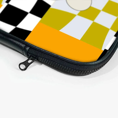 Close-up of laptop sleeve zipper with black, yellow, white, and orange checkered pattern