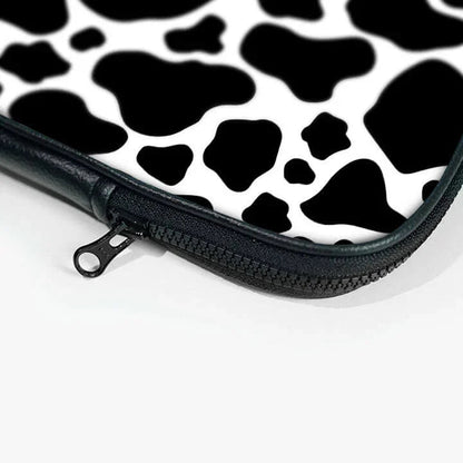 Black and white cow print laptop sleeve with zipper close-up