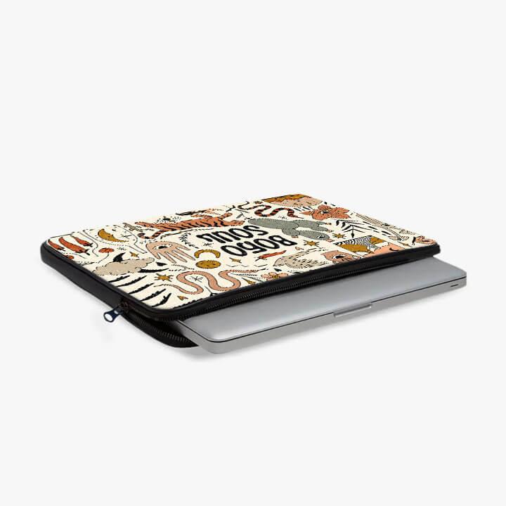 13-inch laptop sleeve with colorful animal illustrations and zip pouch, partially open