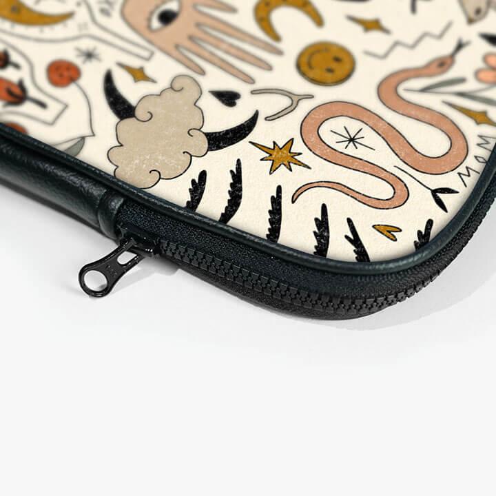 Laptop sleeve with zip closure and abstract hand, snake, and star pattern print