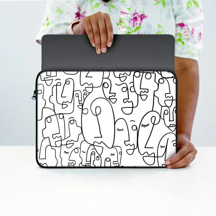 13-inch laptop sleeve with black abstract face line art design, held by person in floral shirt