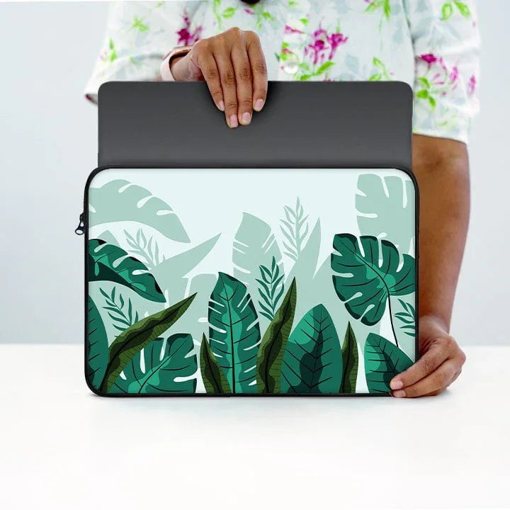 Person holding a 13-inch laptop sleeve with green leaf tropical print on zip pouch
