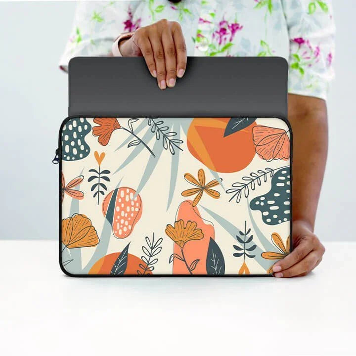 Person holding floral print laptop sleeve with zipper and abstract orange, yellow, green patterns