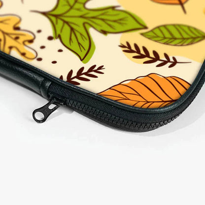 Close-up of laptop sleeve with autumn leaf print and black zipper pouch